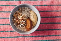 A nutritious blend of oats, nuts, and seeds in a bowl on a vibrant tablecloth.