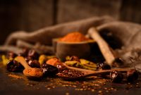 aap-chili-crisp-recipes-to-elevate-every-meal-1791044438 A close-up of rustic spices such as chilies and turmeric on wooden spoons, highlighting food textures.
