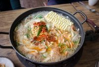 Delicious and spicy Korean ramen soup with vegetables boiling in a pan, capturing the essence of authentic Asian cuisine.