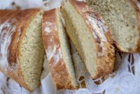 Close-up of freshly baked sliced bread displayed on a lace cloth, highlighting texture.