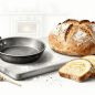 Soda bread, flatbread, and sliced banana bread sit on a flour-dusted board.
